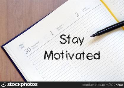 Stay motivated text concept write on notebook with pen