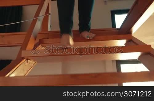 Steadicam shot of a woman going downstairs, taking headphones and cup with tea, sitting on the sofa and starting video chat. She having vivid and emotional talk