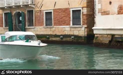 Steadicam shot of a woman photographer making photos of Venice standing by the canal where boat sailing by