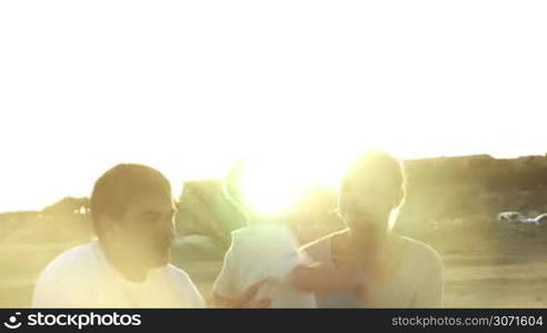 Steadicam shot of child with parents having nice time outdoor. Boy embracing mother, then father taking him on the shoulders and son hugging his dear parents