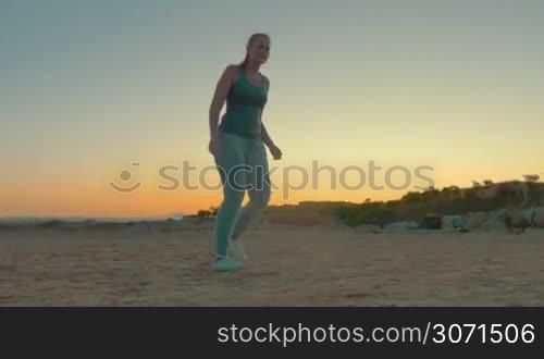 Steadicam shot of four tourists or family playing football on the beach in the evening. Outdoor activity on resort