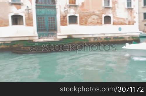 Steadicam shot of motor boat sailing on the canal with following close-up shot of a woman preparing retro camera and taking pictures or shooting video of ancient building