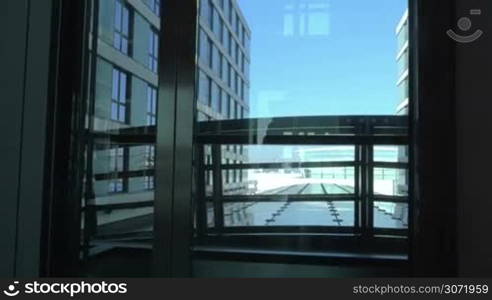 Steadicam shot of young woman with trolley bag walking out the hotel elevator and passing the hall.