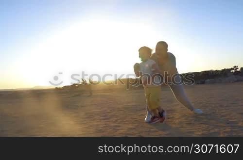 Steadicam slow motion shot of a boy running from mother to father. Father takes him in arms and they begin spinning.
