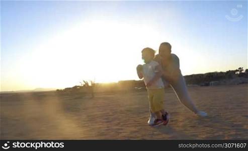 Steadicam slow motion shot of a boy running from mother to father. Father takes him in arms and they begin spinning.