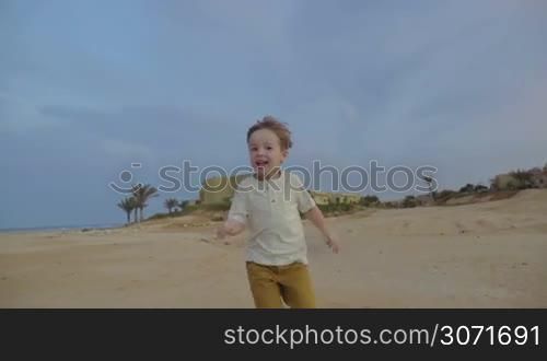 Steadicam slow motion shot of a boy running toward the camera. He&acute;s smiling and enjoying himself.
