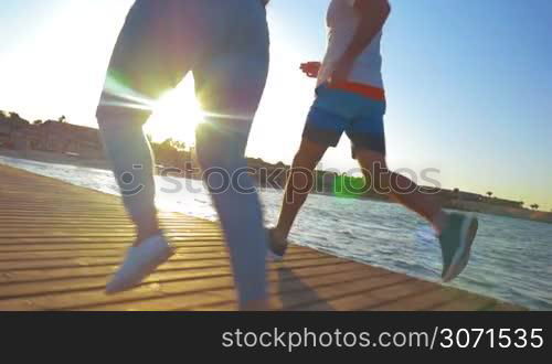 Steadicam slow motion shot of legs of athletic couple went for a run in the morning.