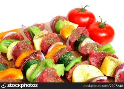 Steak and assoretd vegetables including onion, orange and green bell peppers and summer squash on bamboo skewer sprinkled spices ready for the grill. Steak Kabob