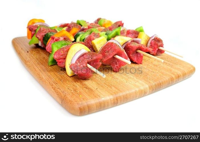 Steak and assoreted vegetables including onion, orange and green bell peppers and summer squash on bamboo skewer sprinkled spices ready for the grill.. Steak And Vegetabe Kabob&rsquo;s