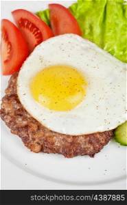 steak beef meat with fried egg, tomato, cucumbers and salad