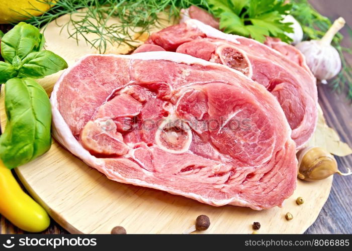 Steak meat raw turkey with pepper, basil, lemon and garlic on a wooden boards background