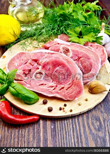 Steak meat raw turkey with pepper, basil, lemon and garlic, vegetable oil in a decanter on a wooden boards background