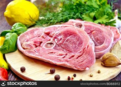 Steak meat raw turkey with pepper, basil, lemon and garlic, vegetable oil on the background of wooden boards