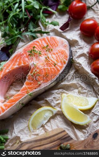 steak of fresh salmon on crushed brown paper with ingredients