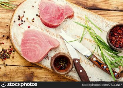 Steak of tuna fish on wooden table. Fresh tuna fish steak