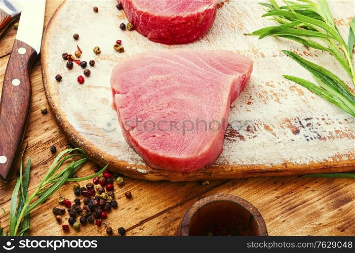 Steak of tuna fish on wooden table. Raw tuna steak