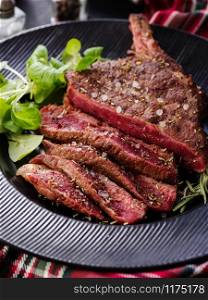 Steak on the bone. Rib eye. Tomahawk steak on the black plate with rosemary. Roasting - Rare. Entrecote.