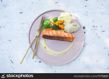 Steak salmon with vegetable broccoli carrot rosemary and lemon on plate seafood / Roasted or grilled salmon steak fish on dining table food outdoor