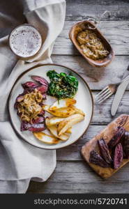 Steak with baked botatoes and green salad on wooden background