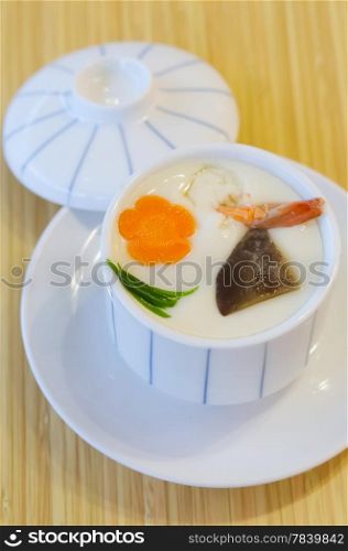 steam egg with meat and vegetable in white bowl on wooden background