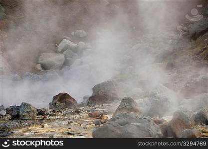 Steam rising from boulders strewn landscape