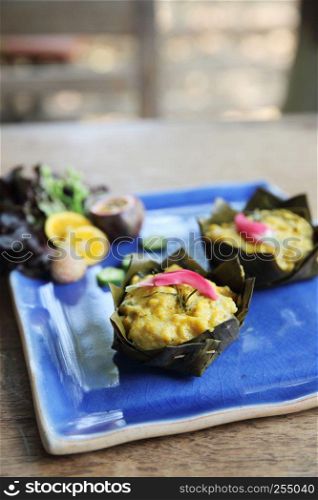 steamed fish with curry paste on wood background