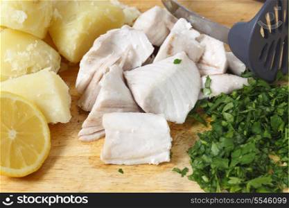 Steamed kingfish chunks with boiled potatoes and parsley, ready to be mashed into homemade fishcake mixture. The lemon adds grated peel.