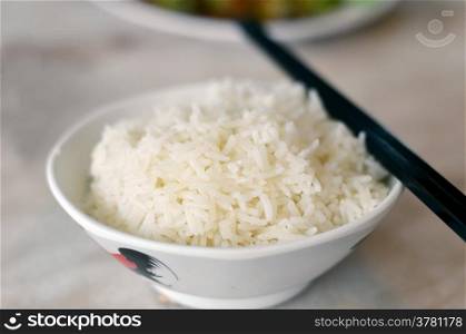 steamed rice in bowl with chopsticks