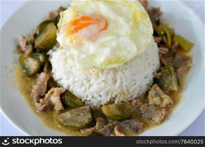 steamed rice served with fried eggs and beef in ground peanut-coconut cream curry
