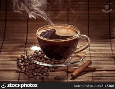 Steaming cup of coffee, cinnamon sticks and a coffee beans. Steaming cup of coffee