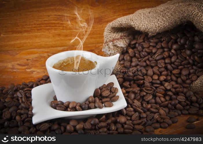 steaming hot cup of coffee with beans