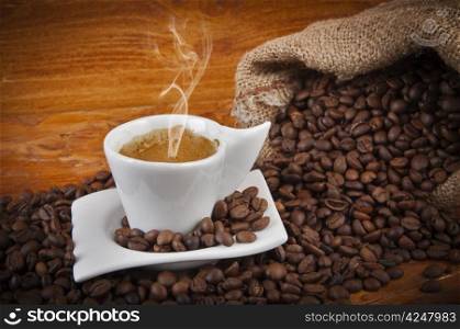 steaming hot cup of coffee with beans