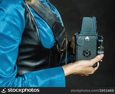 Steampunk with old retro camera.. Photography and retro style. Young vintage attractive girl holds old aged camera. Steampunk photographer taking photo.