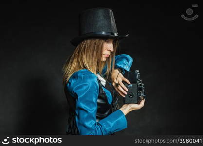 Steampunk with old retro camera.. Photography and retro style. Young vintage attractive girl holds old aged camera. Steampunk photographer taking photo.