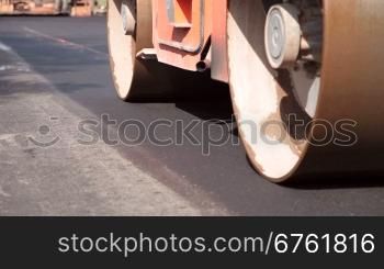 Steamroller compressing asphalt on a new road construction