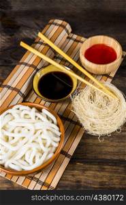 steams udon noodles rice vermicelli sauces with wooden chopsticks place mat against wooden table