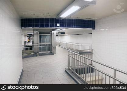 steel and white tiles in empty corridors of subway station new york city
