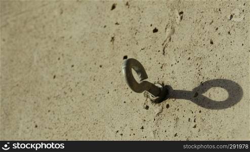 steel bolt anchor eye in the wall shadow. steel bolt anchor eye