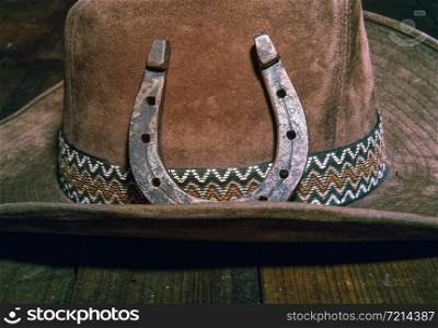 steel classic horseshoe lying on a brown cowboy hat close-up. Horse Shoe hat