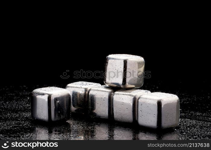 Steel cooling cubes for cocktail drink on glass background.. Steel cooling cubes for cocktail drink on glass background