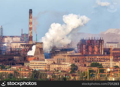 Steel factory with smokestacks at sunset. metallurgical plant. steelworks, iron works. Heavy industry in Europe. Air pollution from smokestacks, ecology problems. Industrial landscape