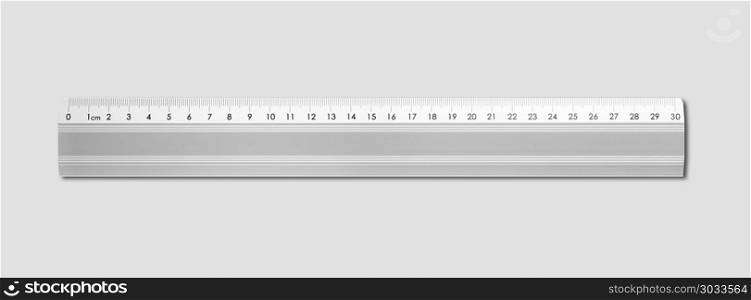 Steel metallic ruler isolated on grey background. Metal ruler isolated on grey background. Metal ruler isolated on grey background