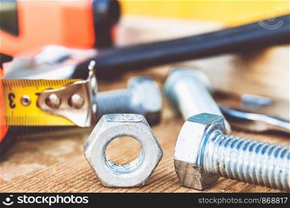 Steel nut bolt and washers lie on wooden boards. The concept of tools and repair work.. Steel nut bolt and washers lie on wooden boards.