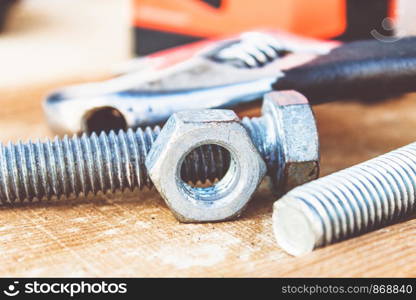 Steel nut bolt and washers lie on wooden boards. The concept of tools and repair work.. Steel nut bolt and washers lie on wooden boards.