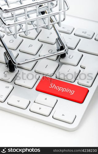 steel shopping cart and keyboard on white background