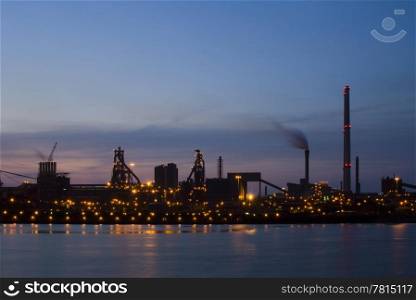 Steelworks at dawn, seen from across a sluice entrance. An industrial, almost silhouette view of heavy industry.