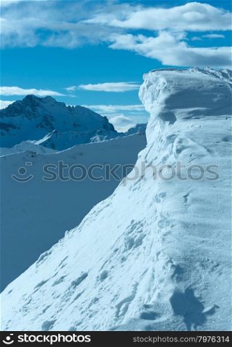 Steep cliff with snow cap in morning winter mountain, Austria.