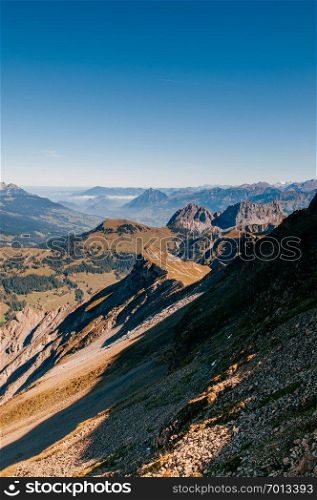 Steep rock cliff and slope of Mount Brienzer Rothorn Swiss alps on blue sky day, Entlebuch, Switzerland