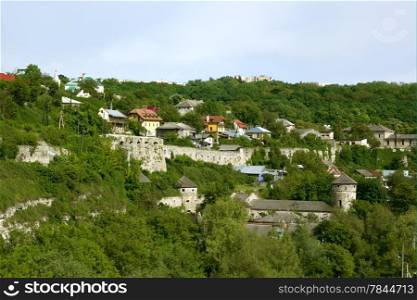 Steep slope near the Smotrych River in the city Kamianets-Podilsky, Ukraine. Modern buildings on the rocks along with remains of medieval fortifications