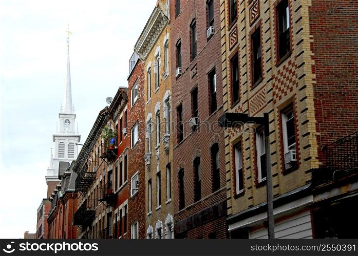 Steeple of Old North Church in Boston North End, row of historical brick buildings in foreground